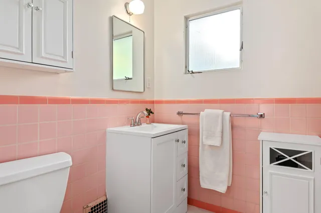 a bathroom with a sink a toilet and a mirror