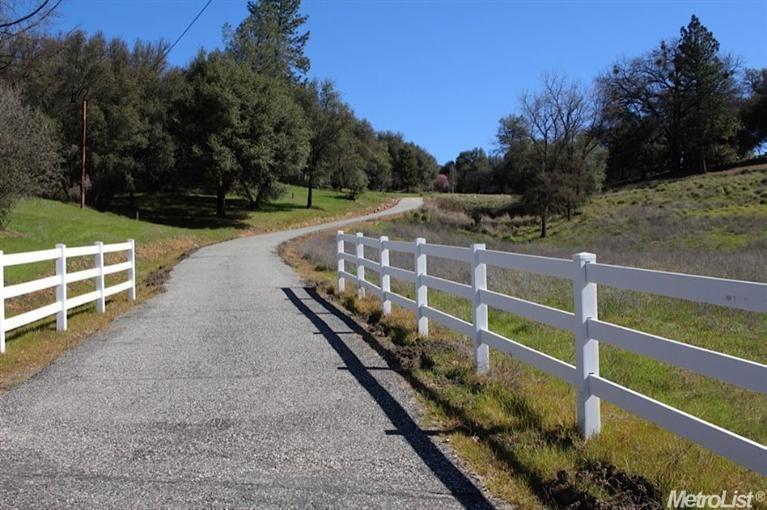 a view of a yard with wooden fence