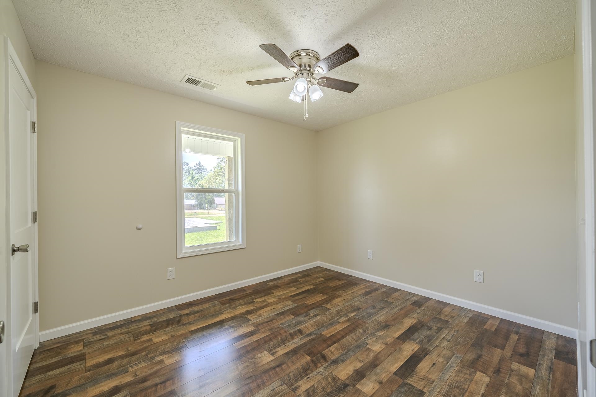 231 Clausel Lane Adamsville, TN 38310 - Photo 17 of 32 wooden floor in an empty room with a window