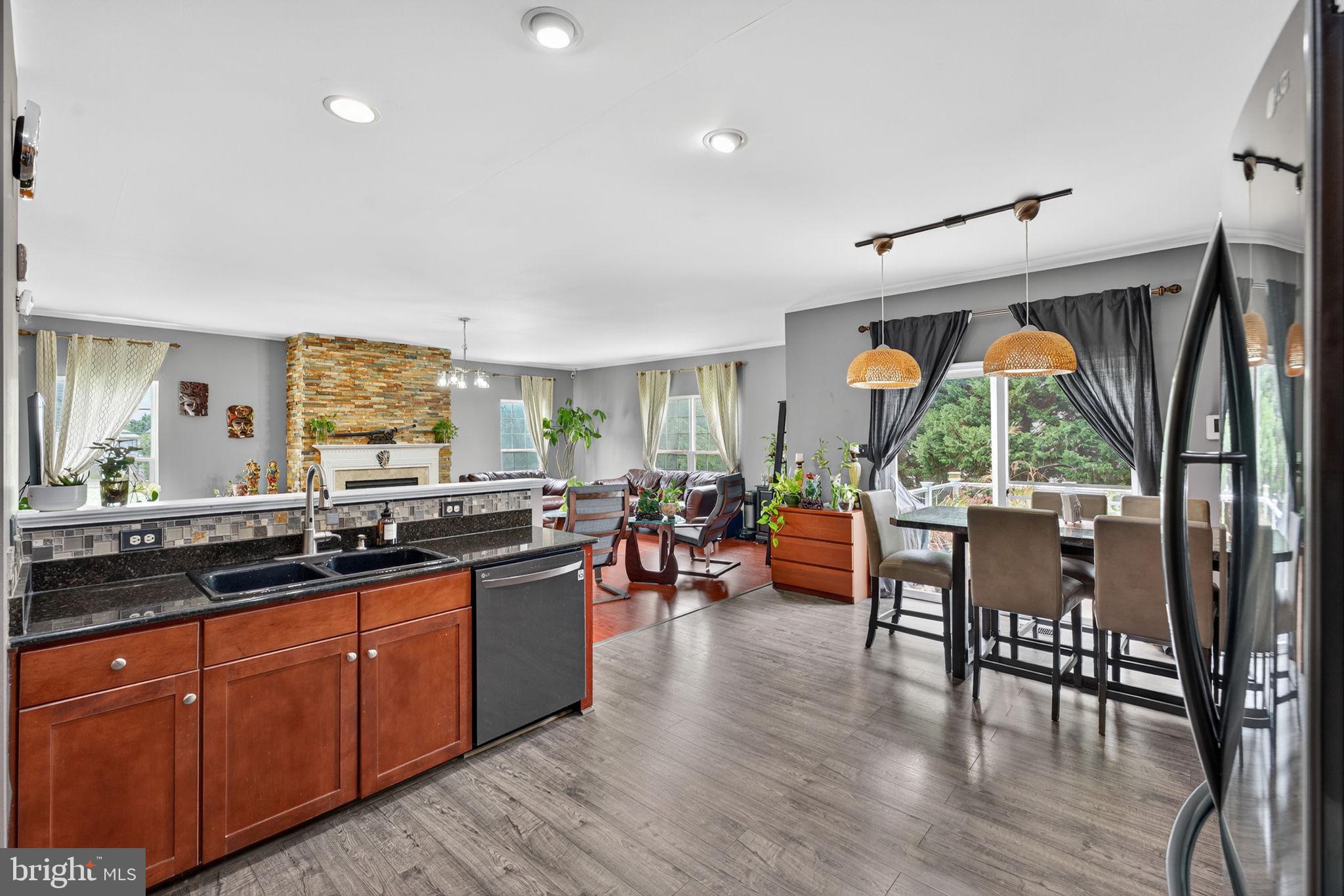 751 Holly Leaf Road Culpeper, VA 22701 - Photo 21 of 65 a kitchen with stainless steel appliances granite countertop wooden floor a dining table and chairs