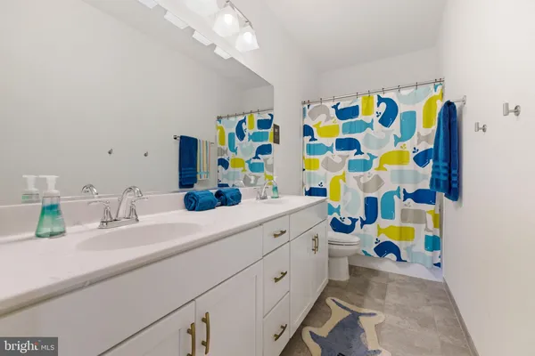 a bathroom with a sink vanity mirror and toilet