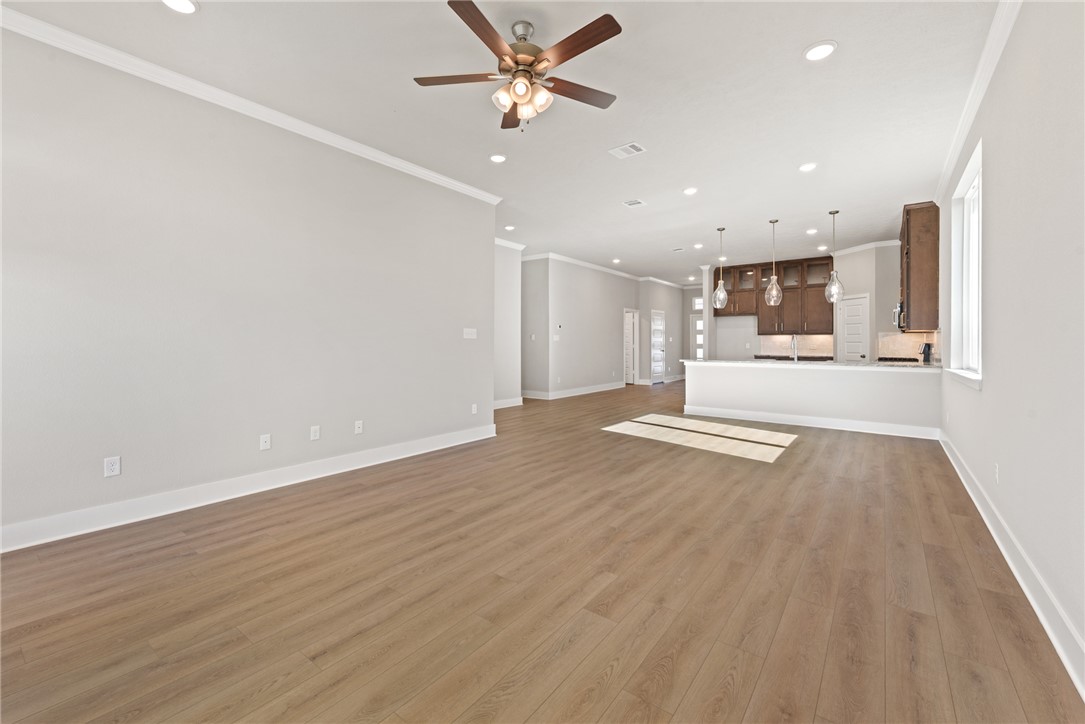 4245 Appalachian Trail Bryan, TX 77802 - Photo 19 of 30 a view of a kitchen with kitchen island a sink wooden floor and a refrigerator