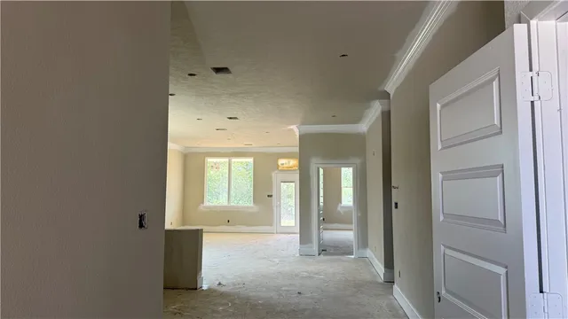 a view of a hallway with wooden cabinets and windows