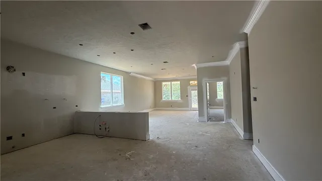 an empty room with windows and cabinet