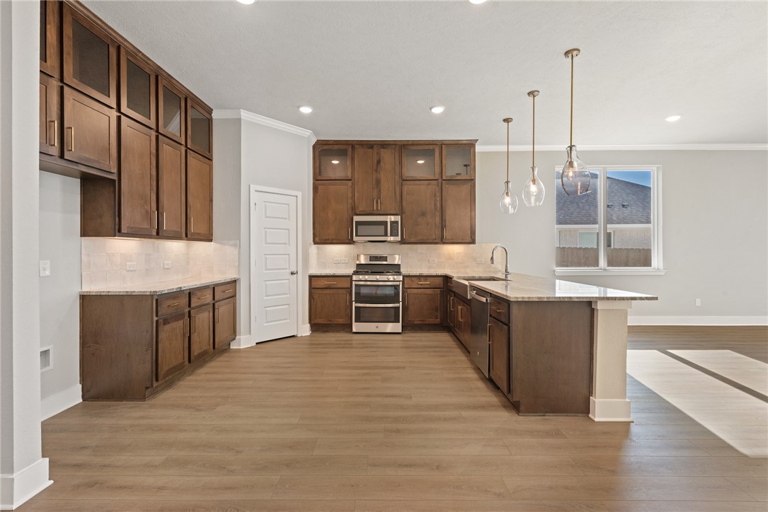 4245 Appalachian Trail Bryan, TX 77802 - Photo 9 of 30 a large kitchen with stainless steel appliances kitchen island granite countertop a stove a sink and a refrigerator