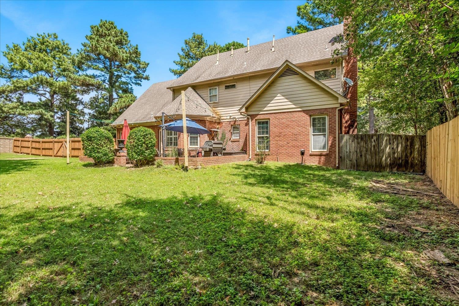 65 Summer Grove Road Memphis, TN 38018 - Photo 34 of 38 Spacious backyard featuring a brick patio, a wooden privacy fence, and mature perimeter trees