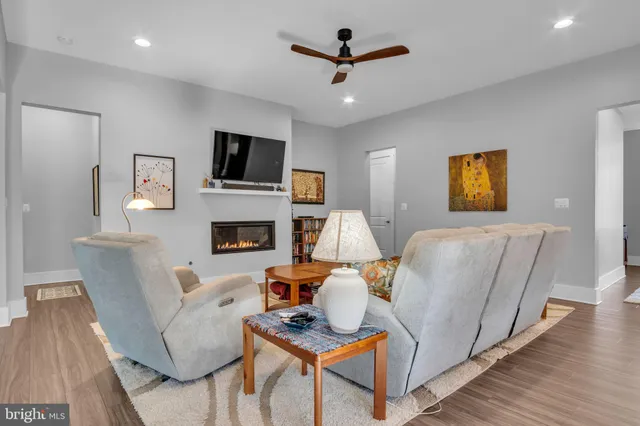 a kitchen with stainless steel appliances kitchen island granite countertop a refrigerator a stove and a wooden floors