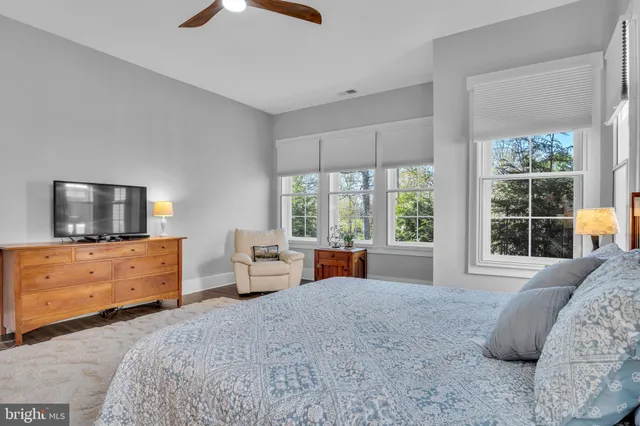 a bedroom with a bed and large windows