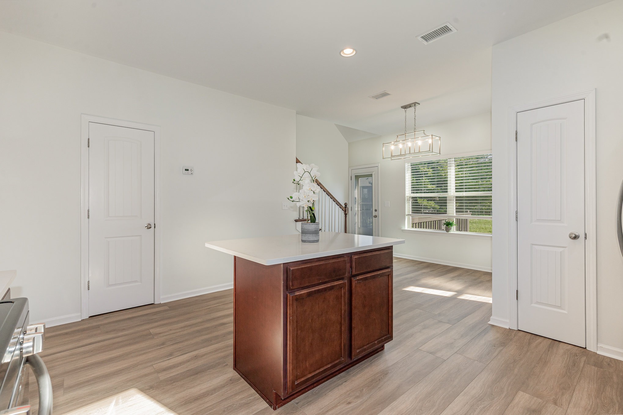 1087 Achiever Circle Spring Hill, TN 37174 - Photo 10 of 39 a kitchen with kitchen island a sink wooden floor and black appliances