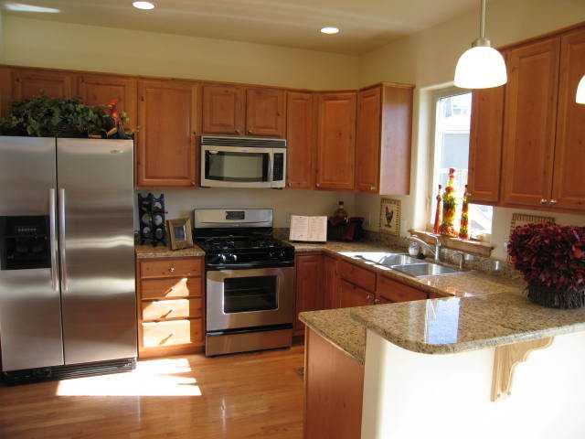 1911 Promontory Circle, Unit LOT 76 Rifle, CO 81650 - Photo 8 of 9 a kitchen with kitchen island granite countertop a stove a sink and a microwave