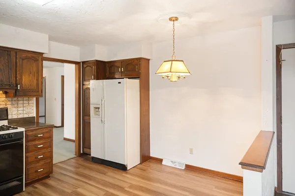 a view of a refrigerator in kitchen and wooden floor