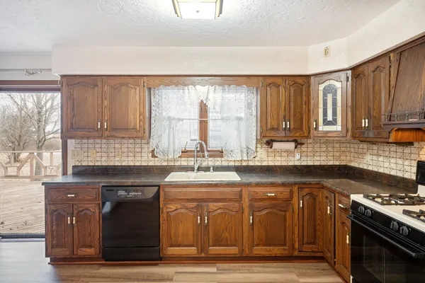 a kitchen with stainless steel appliances granite countertop a stove a sink dishwasher and a microwave oven with cabinets