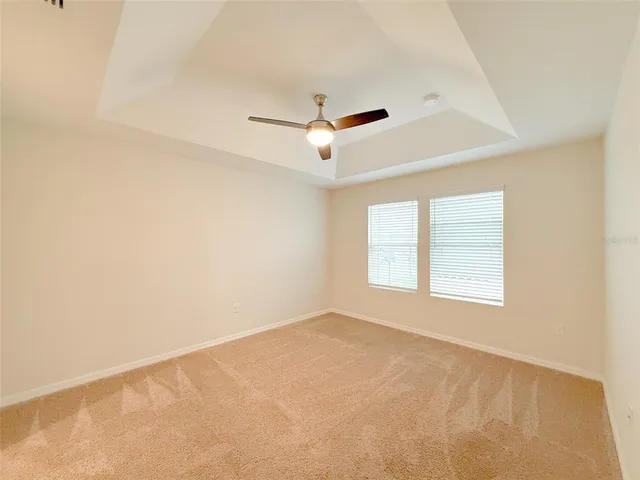 an empty room with a window and a ceiling fan