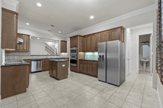a kitchen with stainless steel appliances granite countertop a stove a sink and a refrigerator