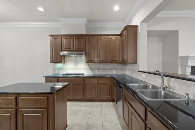 a kitchen with kitchen island granite countertop a sink stainless steel appliances and cabinets