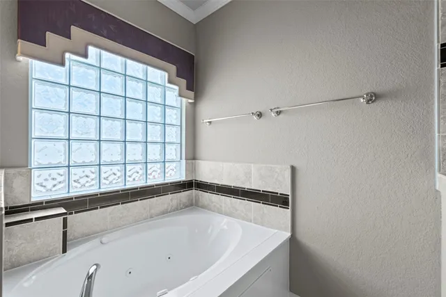 a bathroom with a bathtub and next to a window