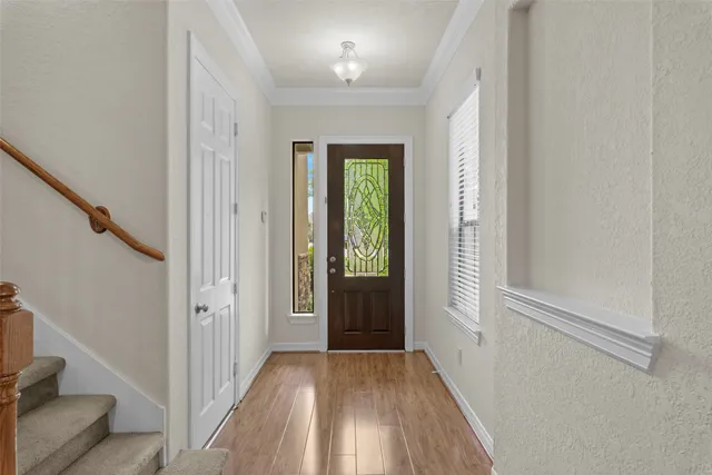 a view of a hallway with wooden floor and stairs