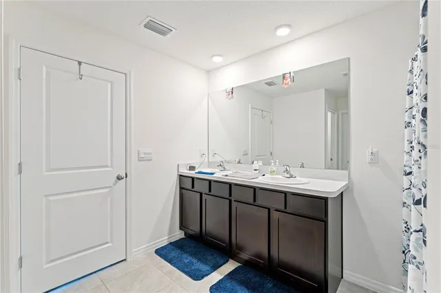 a bathroom with a double vanity sink and mirror