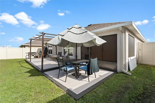 a view of a house with backyard and sitting area