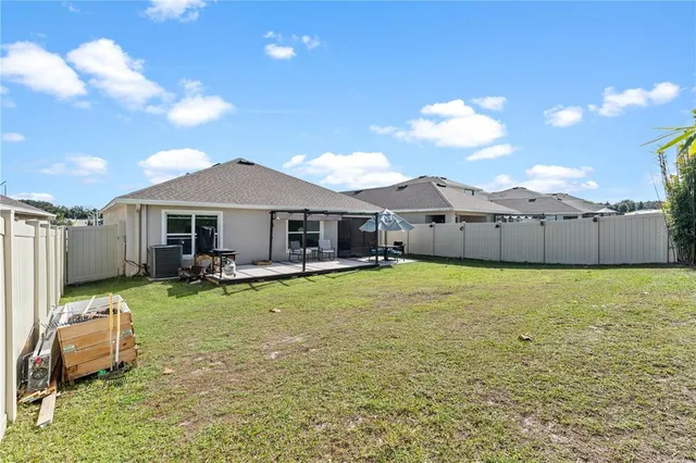 a view of a house with backyard and sitting area