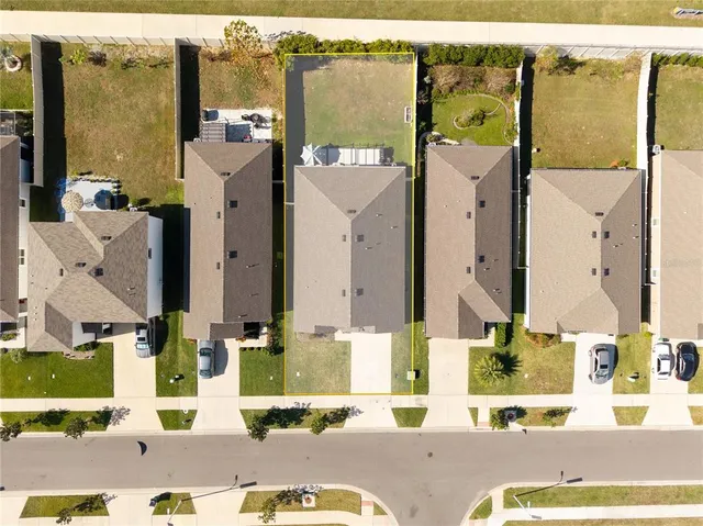 an aerial view of residential houses with outdoor space and parking