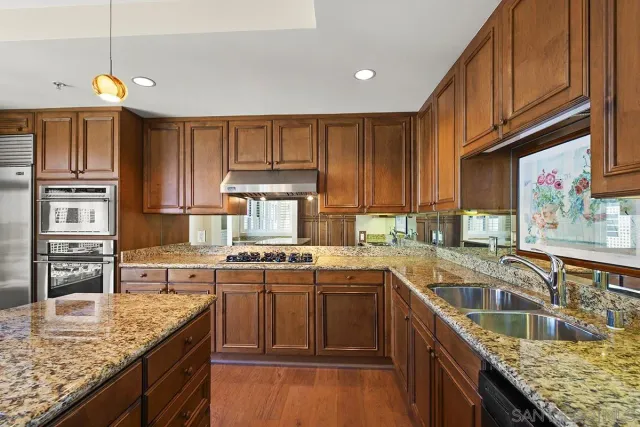 a kitchen with stainless steel appliances granite countertop a sink stove and refrigerator