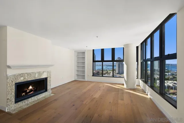 a view of an empty room with a fireplace and a window