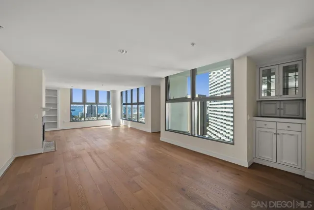 a view of an empty room with a kitchen and a window