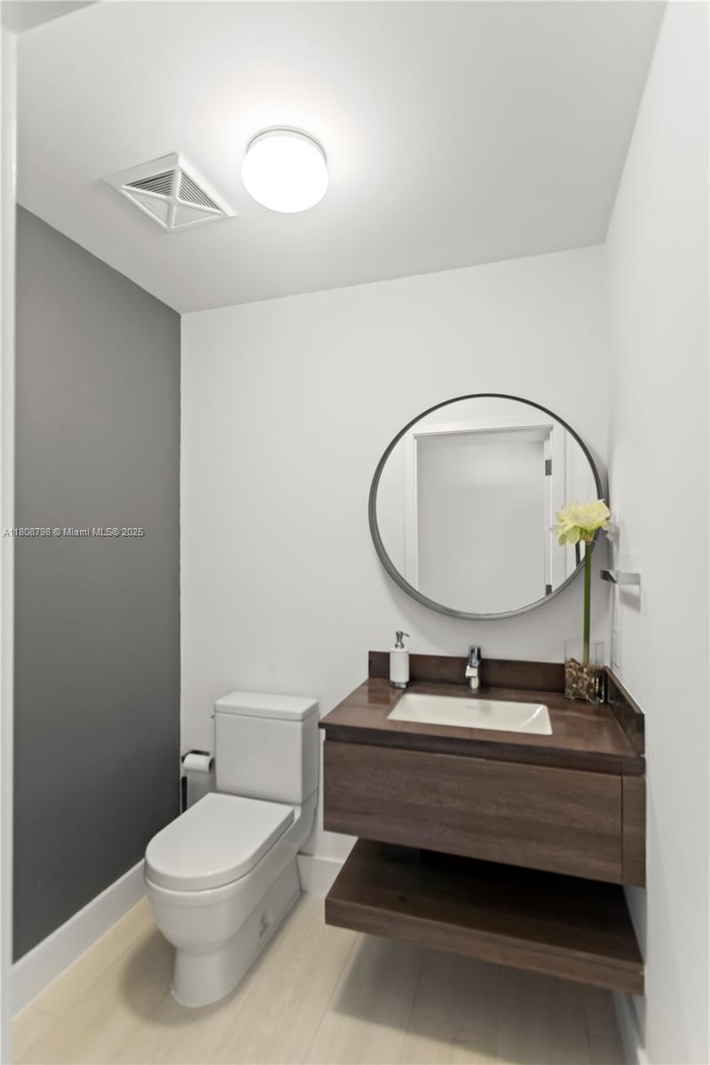 350 Ocean Drive, Unit 904N Key Biscayne, FL 33149 - Photo 31 of 41 a bathroom with a toilet a sink and mirror
