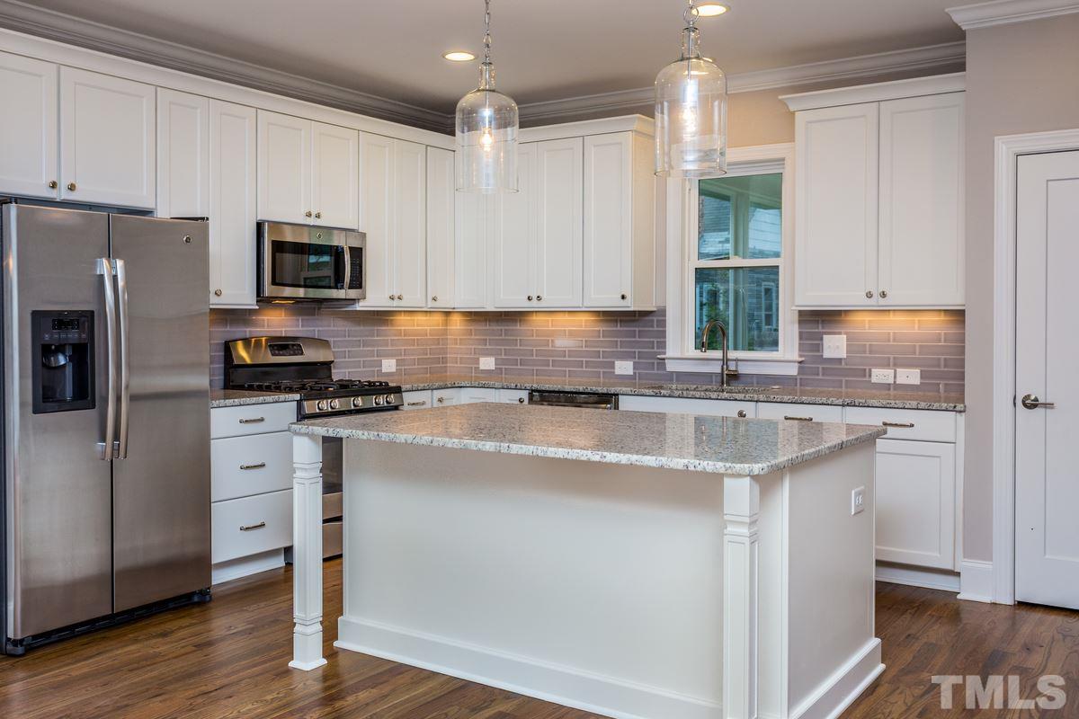 208 Bladen Street Raleigh, NC 27601 - Photo 6 of 25 a kitchen with stainless steel appliances granite countertop a stove a sink a refrigerator a microwave and cabinets