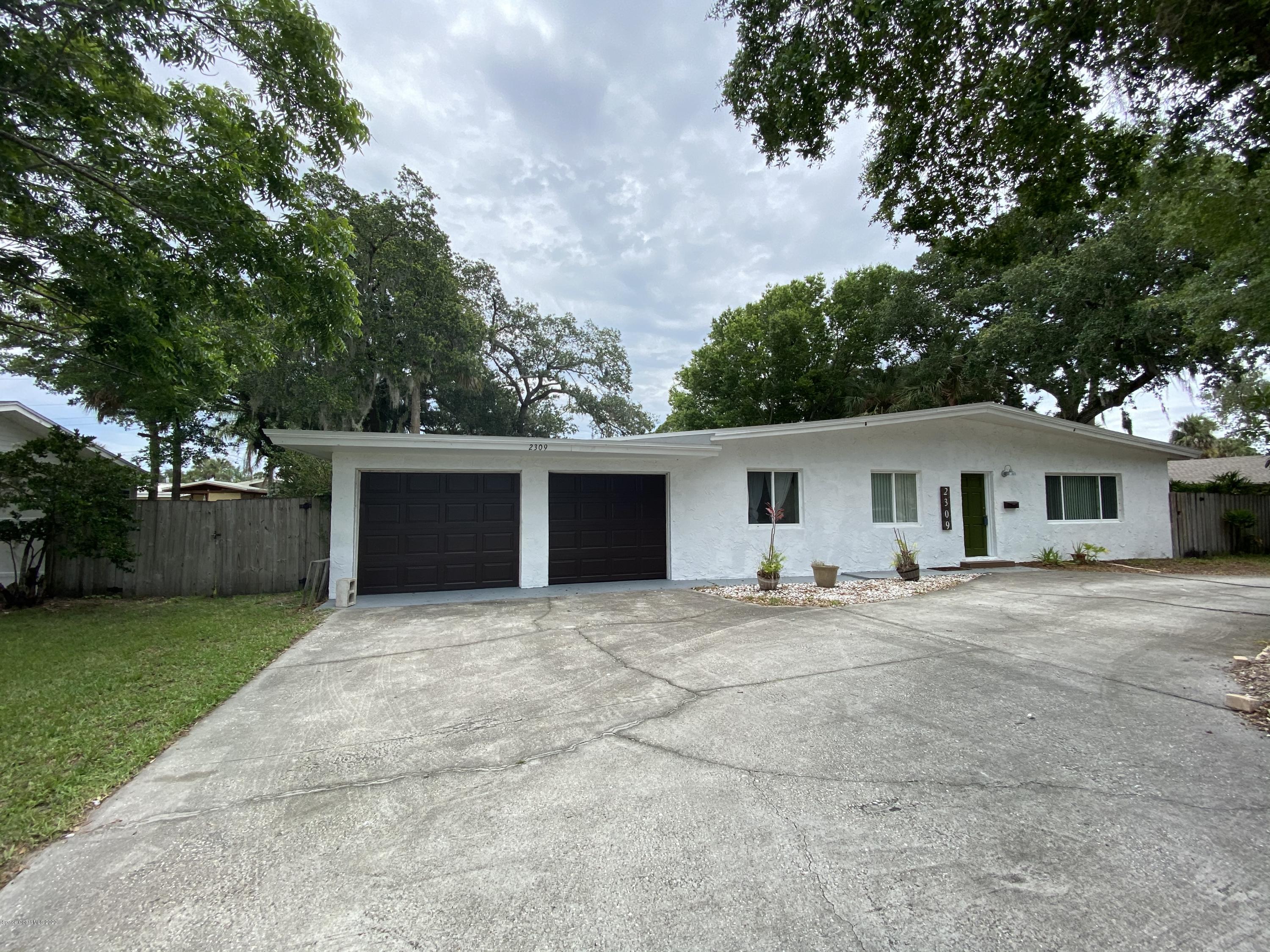 2309 Country Club Road Melbourne, FL 32901 - Photo 1 of 50 a house with trees in the background