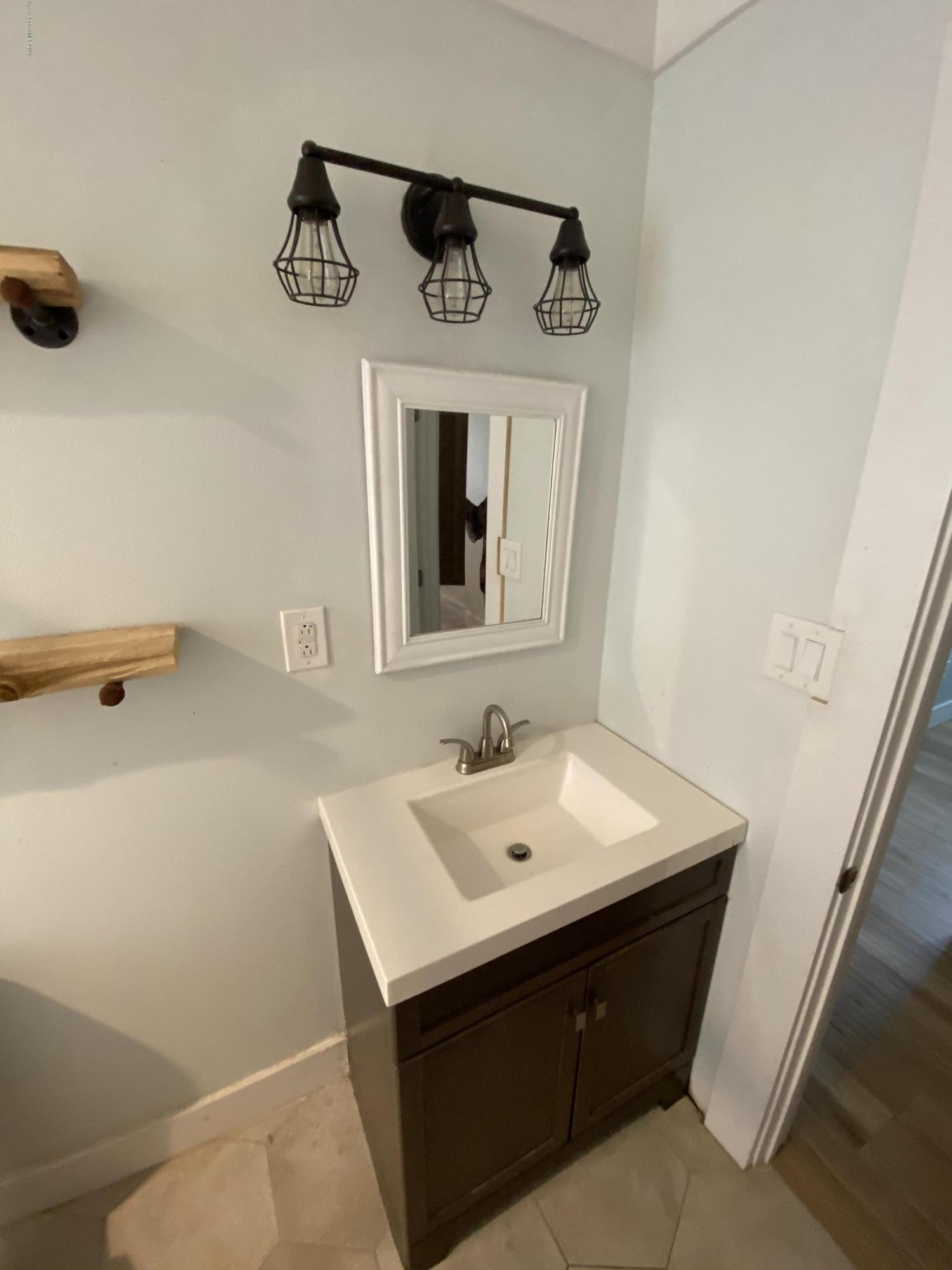 2309 Country Club Road Melbourne, FL 32901 - Photo 20 of 50 a bathroom with a sink and a mirror