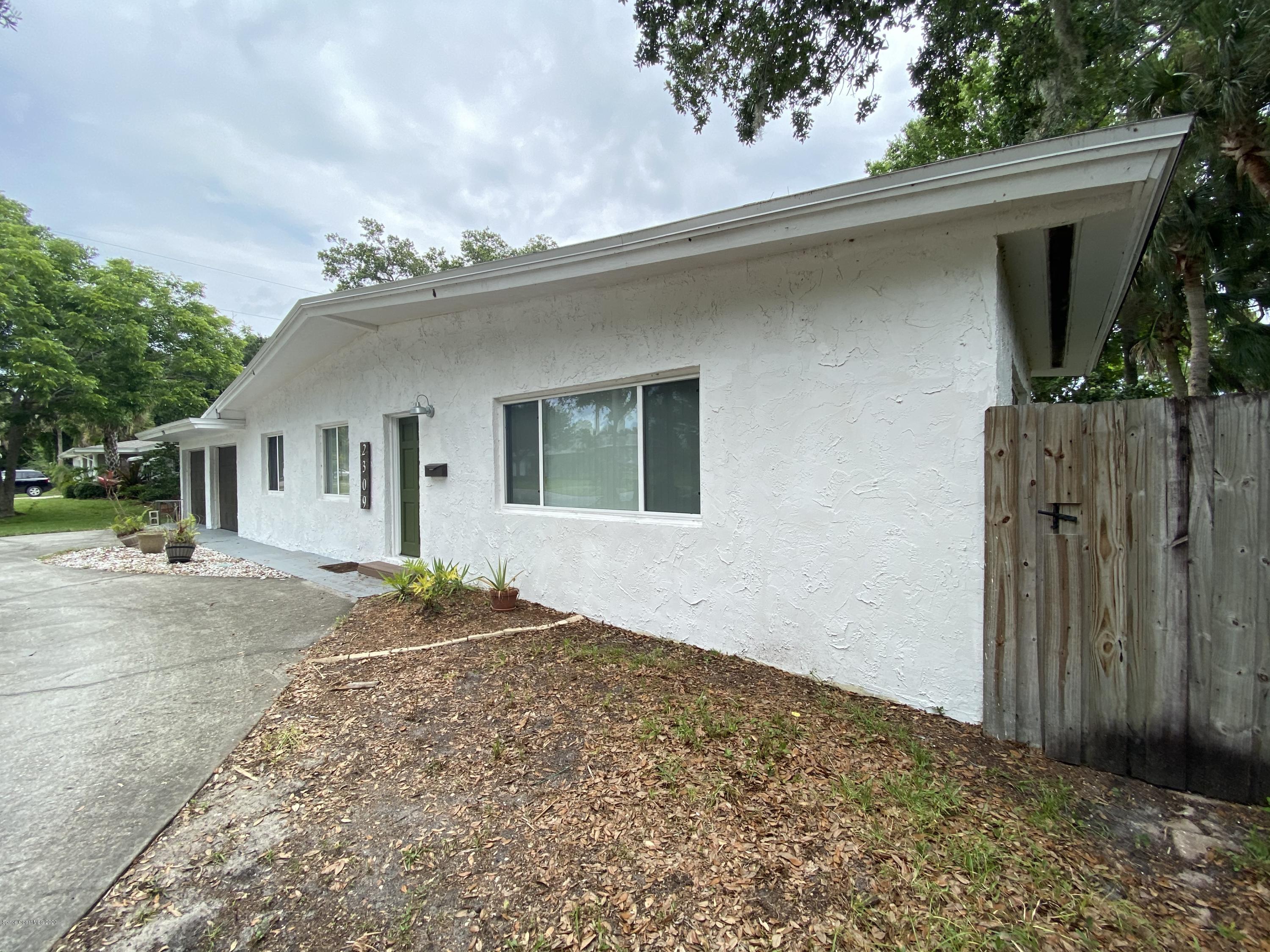 2309 Country Club Road Melbourne, FL 32901 - Photo 3 of 50 a front view of a house with a yard