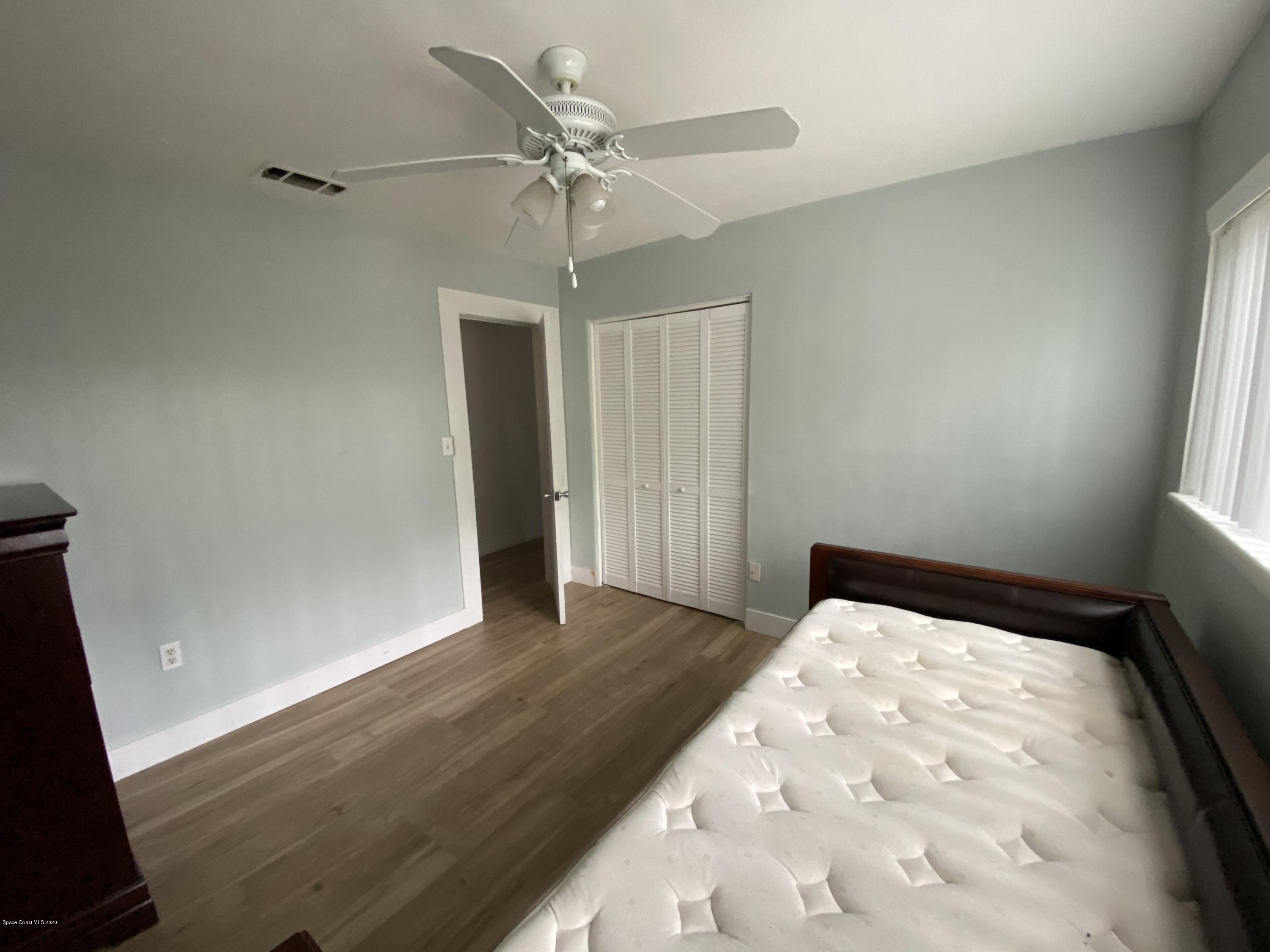 2309 Country Club Road Melbourne, FL 32901 - Photo 24 of 50 an empty room with wooden floor fan and windows