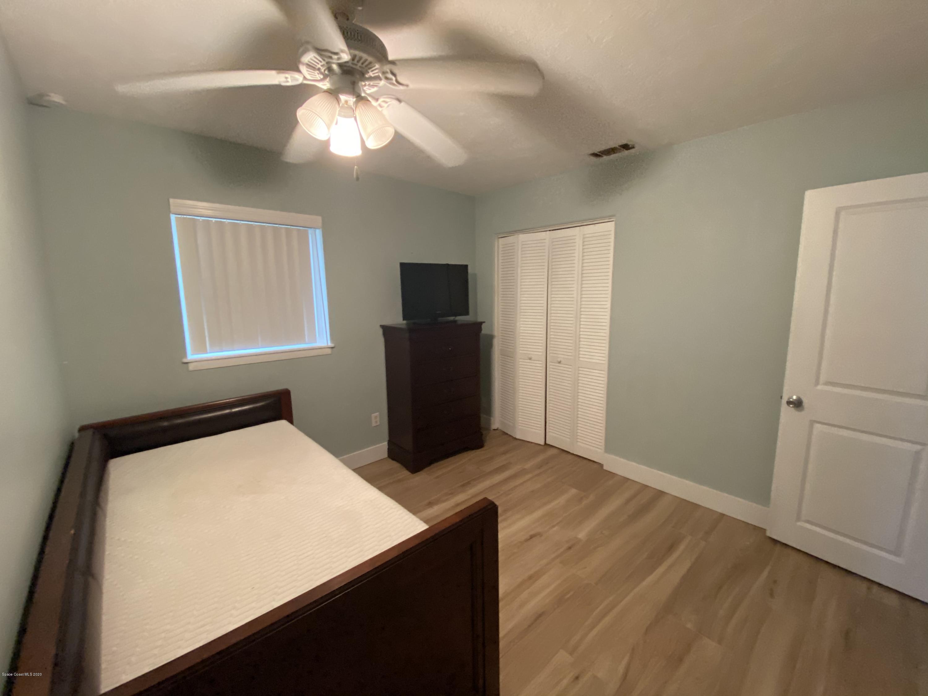 2309 Country Club Road Melbourne, FL 32901 - Photo 26 of 50 a bed room with a bed and a chandelier