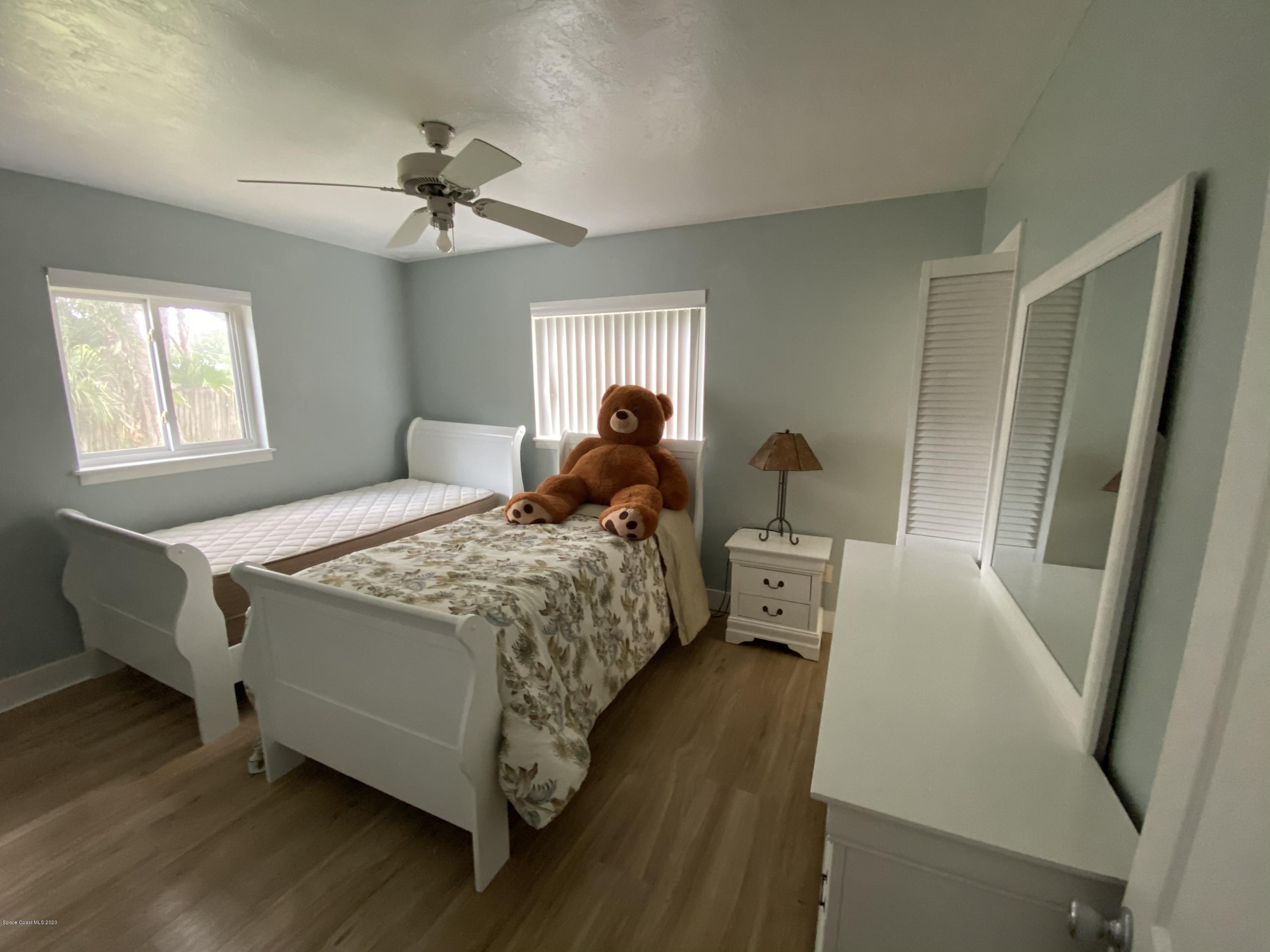 2309 Country Club Road Melbourne, FL 32901 - Photo 29 of 50 a bedroom with a bed and a chandelier