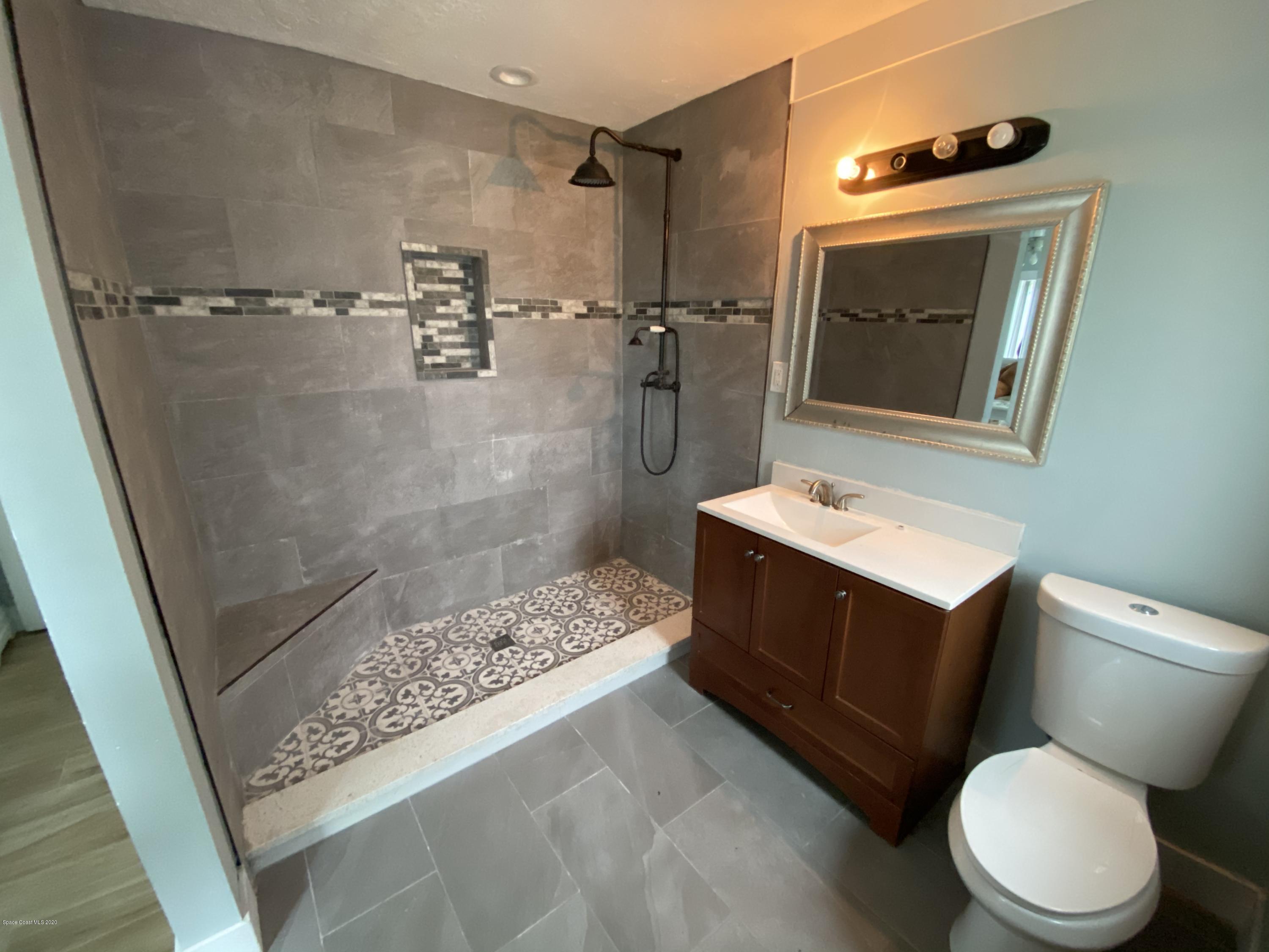 2309 Country Club Road Melbourne, FL 32901 - Photo 32 of 50 a bathroom with a sink a toilet and shower
