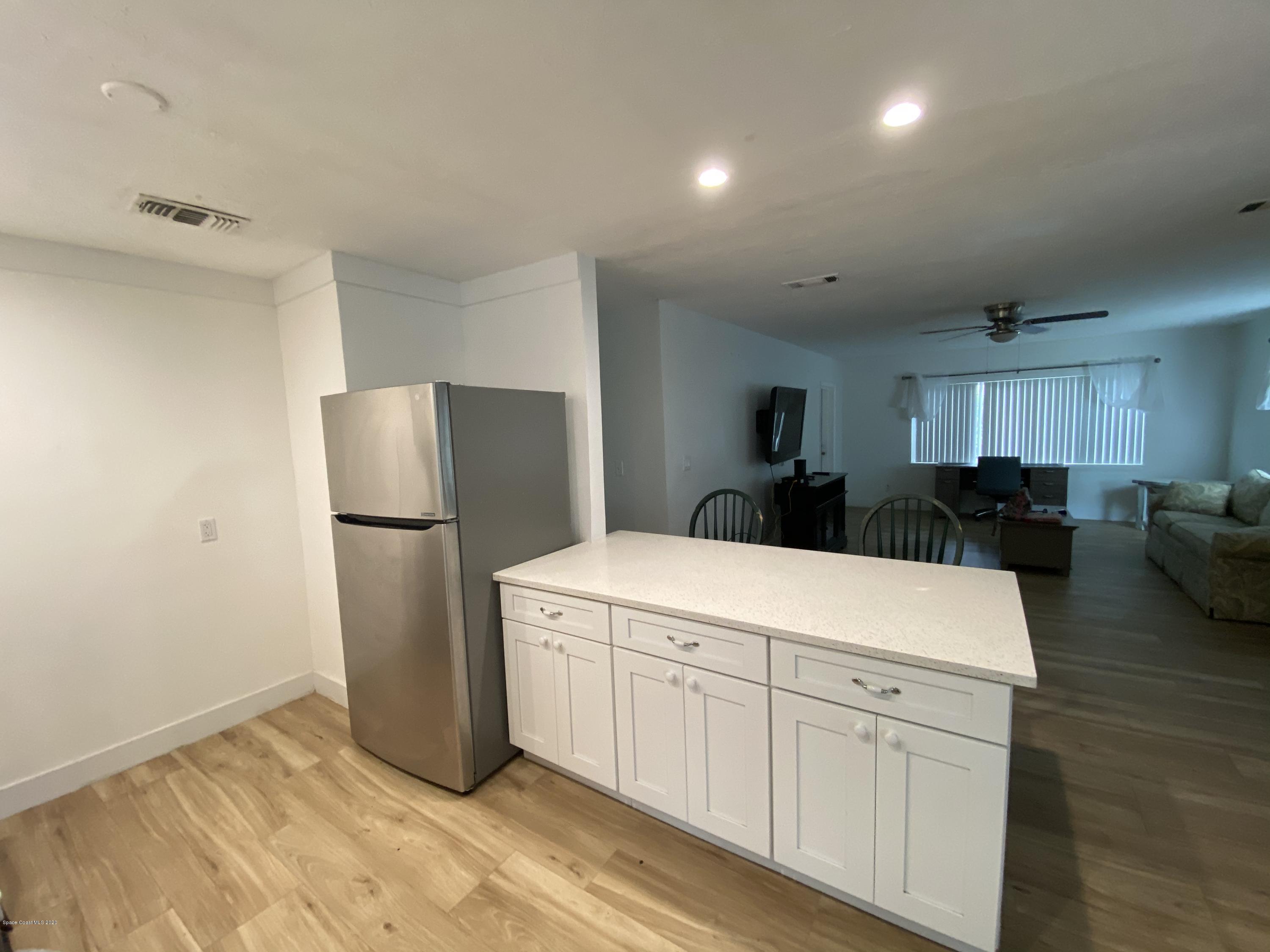 2309 Country Club Road Melbourne, FL 32901 - Photo 6 of 50 a kitchen with a refrigerator a stove and a cabinets