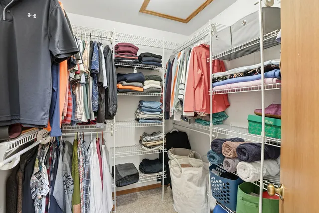 a view of walk in closet with clothes and shoes