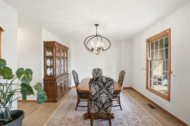 a dining room with furniture potted plants and wooden floor