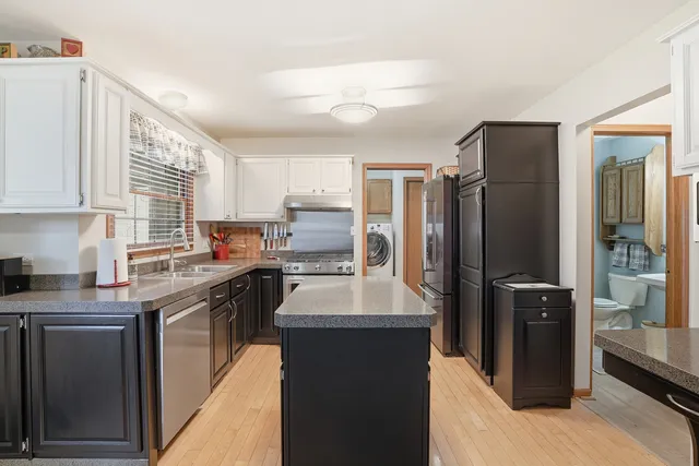 a kitchen with a refrigerator sink and wooden cabinets
