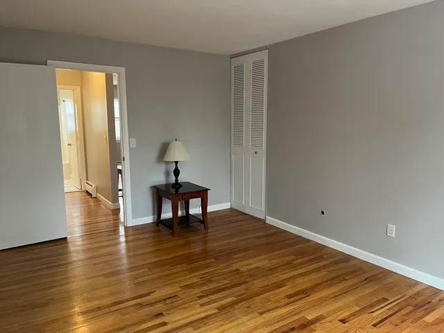 a view of a room with wooden floor table and chairs