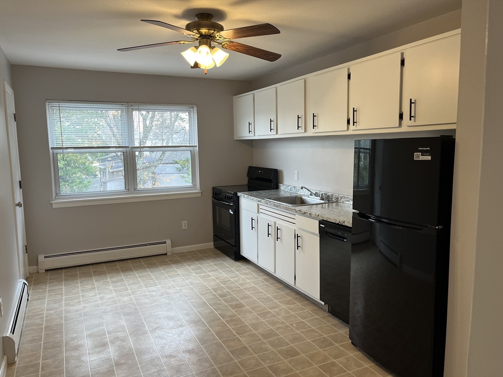 114 Colonial Circle, Unit C Chicopee, MA 01020 - Photo 2 of 16 a kitchen with stainless steel appliances granite countertop a refrigerator a stove a sink dishwasher and white cabinets with wooden floor