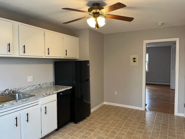 a kitchen with granite countertop a sink a stove and cabinets