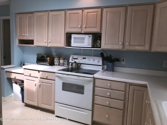a kitchen with granite countertop white cabinets and white appliances