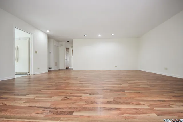 a view of empty room with wooden floor