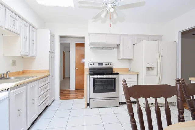 a kitchen with white cabinets and appliances