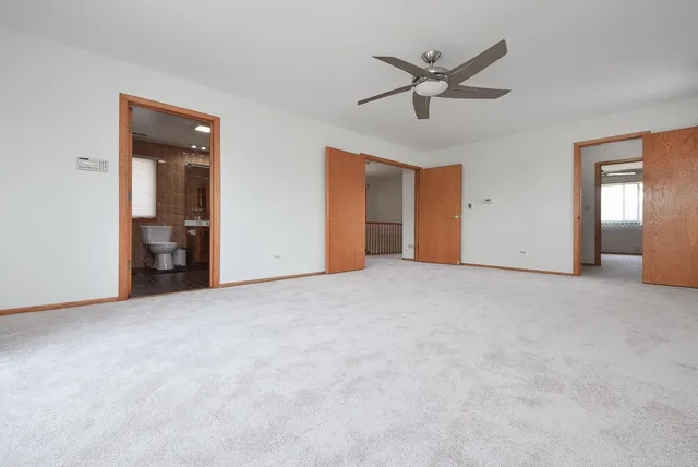 a view of an empty room with a ceiling fan