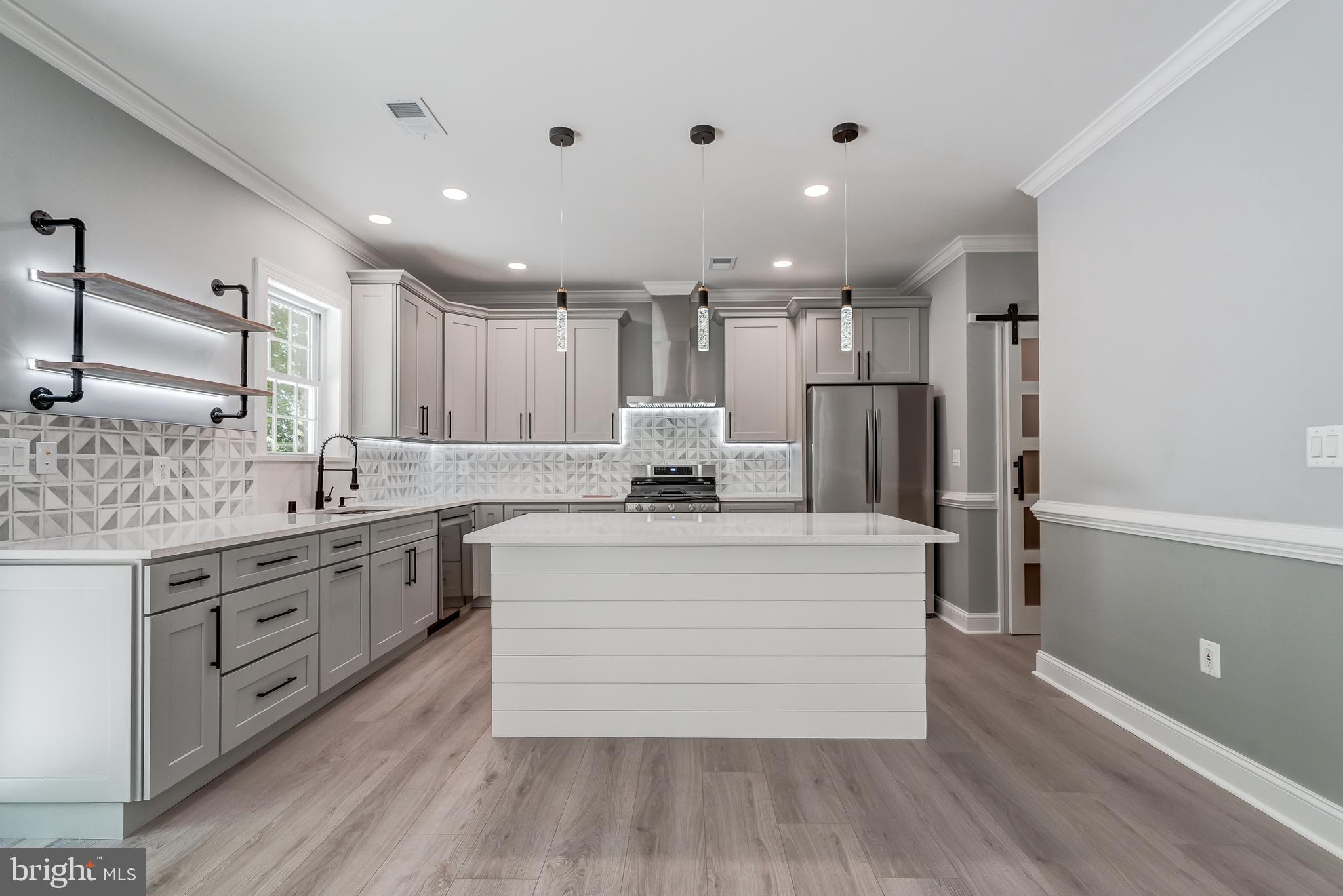 50 Retriever Court Bumpass, VA 23024 - Photo 27 of 77 a large white kitchen with a stove a sink a refrigerator and white cabinets with wooden floor