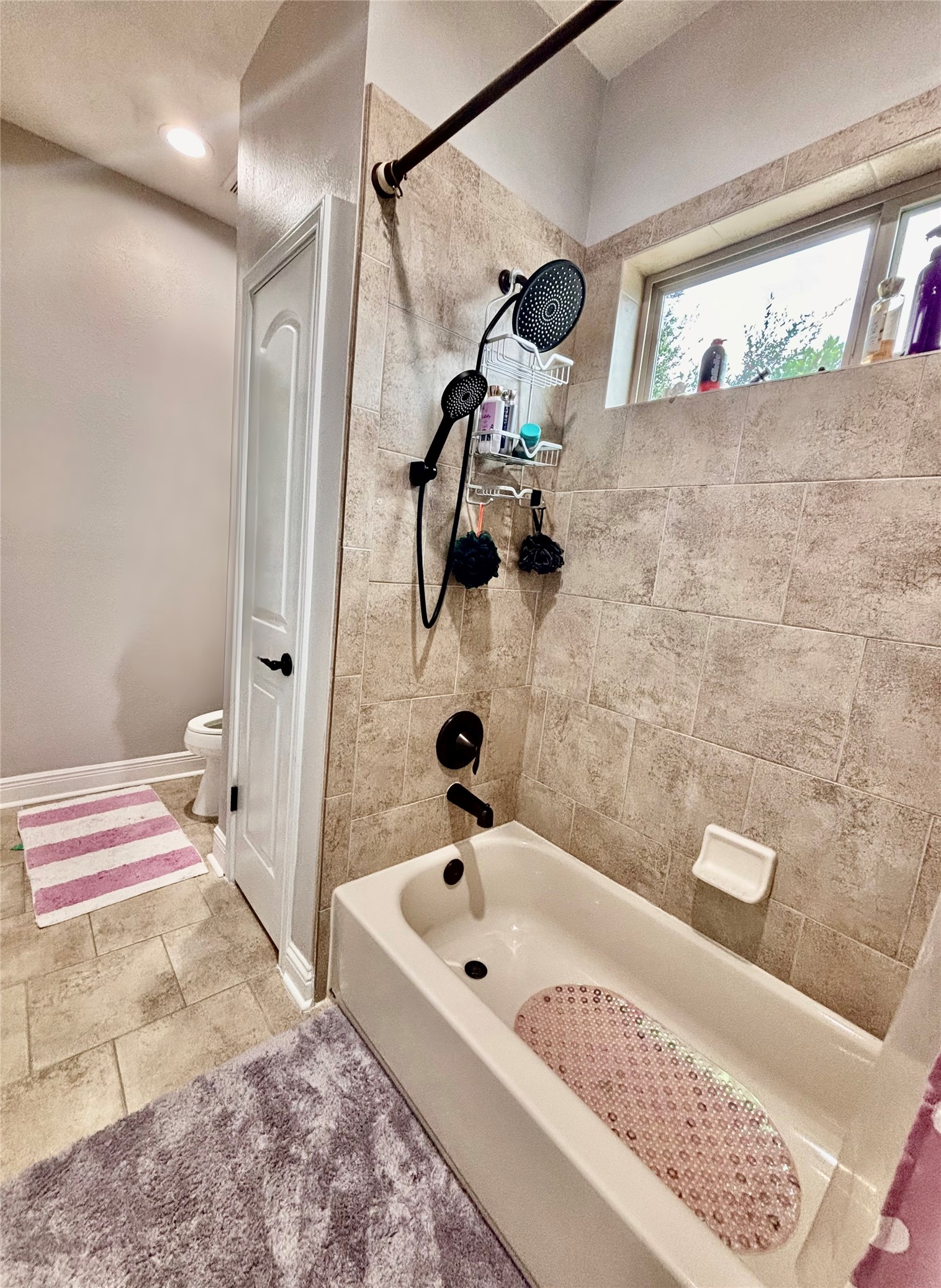 13510 Cascade Caverns Court Houston, TX 77044 - Photo 31 of 37 A modern 2nd bathroom featuring a combination tub and shower , dual shower heads, tiled walls.